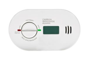 Carbon monoxide alarm with test and reset dial, digital display, and indicator lights.